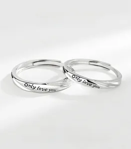Macro shot of silver couple rings with Mobius twist design and Only Love You engraving