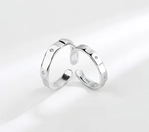 Detail of S925 sterling silver couple rings with hammered texture and tiny zircon inlay