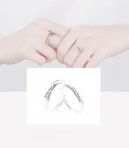 Detail of silver couple rings with Only love you engraving and minimalist design