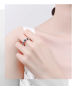 Close-up of minimalist S925 silver wave ring with black enamel drips on model finger