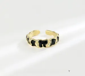 Macro detail of S925 sterling silver stamp on golden ring with black enamel wavy texture