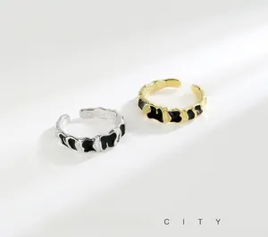 Detail of irregular S925 silver and gold rings with black enamel melt texture