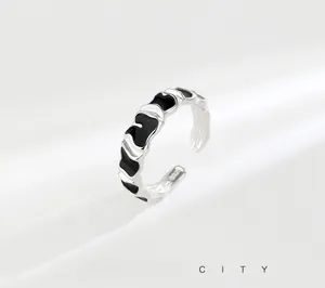 Macro shot of S925 sterling silver ring showing irregular melting texture and black enamel