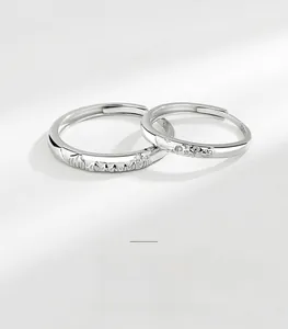 Detailed macro view of S925 silver couple rings featuring mountain and wave engravings