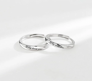 Detail of S925 sterling silver couple rings with Only Love You engraving and twist design