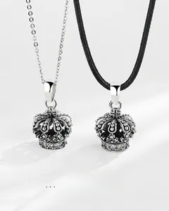 Détail de pendentifs couronne en argent vintage avec cristaux sur chaîne et cordon noir