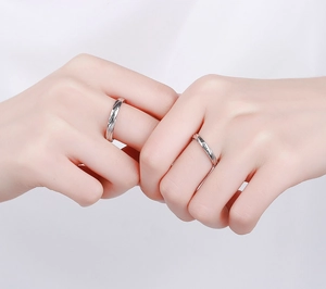Detail of Mobius silver rings with Only Love engraving on couple's holding hands