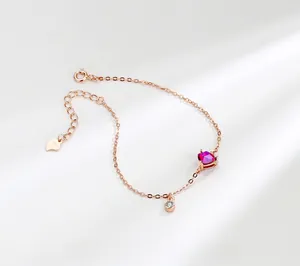 Macro shot of rose gold heart pendant with S925 silver clasp and red gemstone