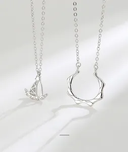 Macro view of S925 sterling silver sailboat pendants and wave ring necklaces