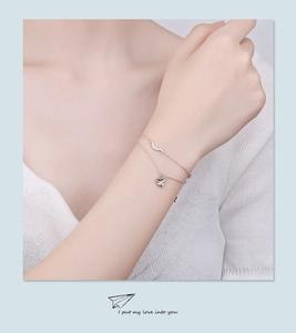 Gros plan détaillé du bracelet double couche en argent S925 avec avion en papier et cristaux