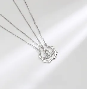 Macro shot of silver sailboat pendant featuring detailed micro-inlaid cubic zirconia