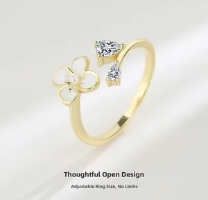 Detail of adjustable gold ring featuring enamel flower, white pearl, and zircon heart stones