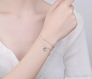 Détail du bracelet en argent S925 avec pendentif avion en papier et double chaîne