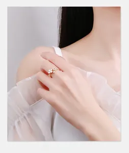 Detail of gold flower ring with pearls and zircons worn on model finger