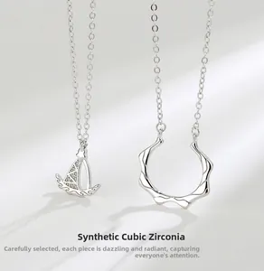 Detail of S925 silver necklaces featuring a sailboat pendant and a cubic zirconia wave ring