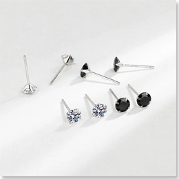 Macro shot of 925 sterling silver stud earrings with round-cut white and black stones
