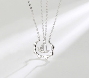 Macro detail of S925 silver sailboat pendant with shimmering pave-set crystals