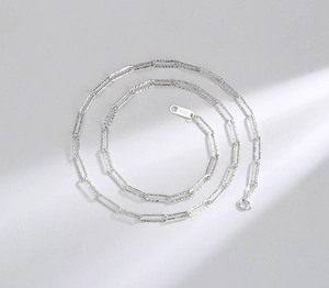 Macro shot of S925 sterling silver paperclip chain necklace with faceted texture detail