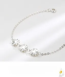 Detail of S925 sterling silver bracelet featuring three polished daisy floral pendants