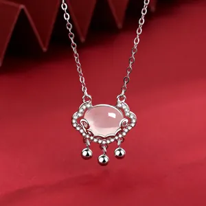 Macro shot of silver Auspicious Cloud Lock necklace with pink gemstone and white zircons