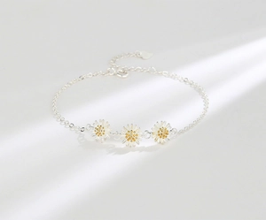 Detail shot of a S925 sterling silver daisy bracelet with golden flower centers