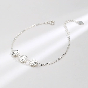 Elegant S925 sterling silver bracelet featuring three daisy charms and heart pendant
