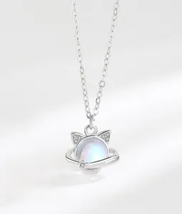Macro detail of S925 silver cat planet pendant with moonstone and sparkling crystals