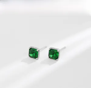 Makroaufnahme quadratischer Smaragd-Ohrstecker mit feiner Silberperlenverzierung
