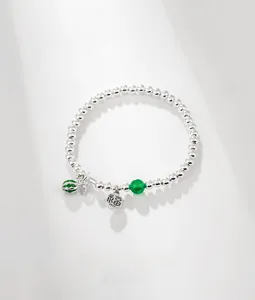 Macro shot of S925 sterling silver beaded bracelet featuring a green watermelon charm and Fu tag