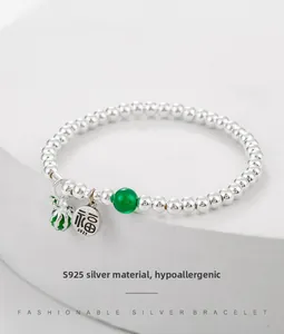 Detail of S925 sterling silver beaded bracelet with enamel Fu charm and green bead