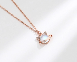 Detail of rose gold cat planet pendant with moonstone and sparkling diamonds