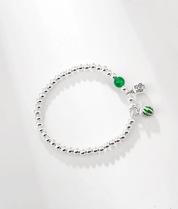 Detail of S925 sterling silver beaded bracelet with green enamel pendant and Fu tag