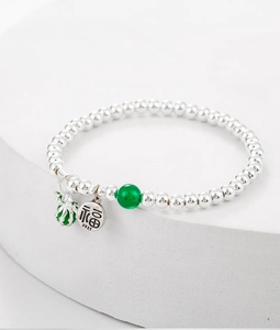 Macro shot of S925 silver beaded bracelet with enamel watermelon and Fu character charms
