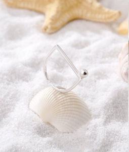 Minimalist S925 silver square open ring placed on a white shell at the beach