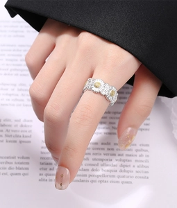 Close-up of S925 sterling silver daisy ring featuring detailed yellow floral centers