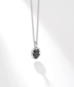 Close-up of S925 sterling silver necklace with oval black zircon pendant in claw setting