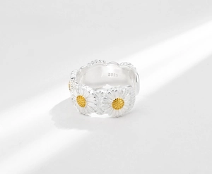 Macro detail of S925 sterling silver stamp and yellow enamel daisies on the ring band