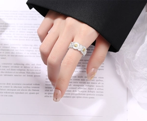Detailed view of sterling silver daisy ring on finger with elegant floral design