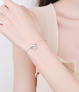 Macro shot of silver dolphin bracelet with white mother of pearl inlay on model wrist
