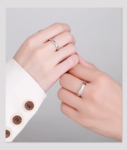 Close-up of S925 sterling silver knot couple rings on hands with a polished finish