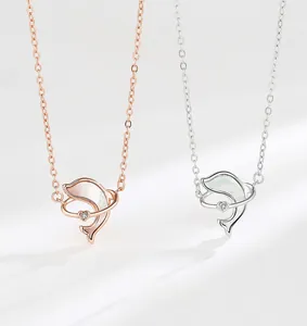 Detail of dolphin necklaces with mother of pearl inlay and heart shaped zircon pendants