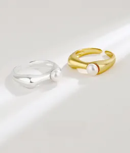 Close-up of minimalist adjustable S925 silver and gold rings with freshwater pearls