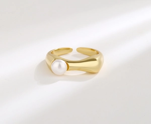 Detail of S925 silver adjustable ring with a glossy white freshwater pearl in gold finish