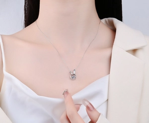 Close-up of S925 sterling silver moving bunny necklace with sparkling crystal on a model