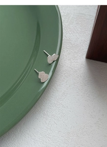 Detail of silver gourd stud earrings featuring a textured crushed ice matte surface