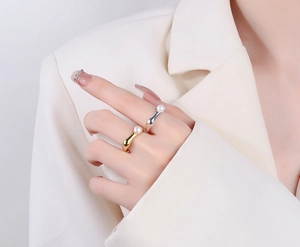 Close-up of minimalist S925 silver wave rings with freshwater pearls on model finger
