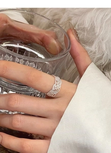 Détail macro d'une bague multicouche en argent 925 tressé portée au doigt