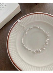 Détail d'un bracelet en argent sterling S925 avec perles sur un plat en céramique