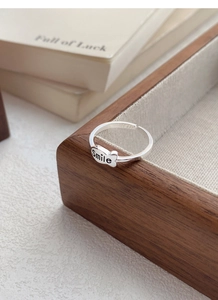 Detailed view of S925 sterling silver smile ring on a wooden tray with a warm natural tone