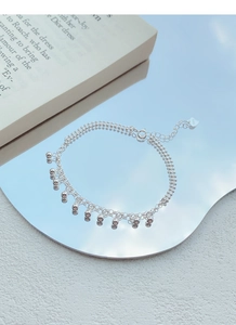 Vue détaillée du bracelet en argent S925 avec perles se reflétant sur un miroir et ciel bleu